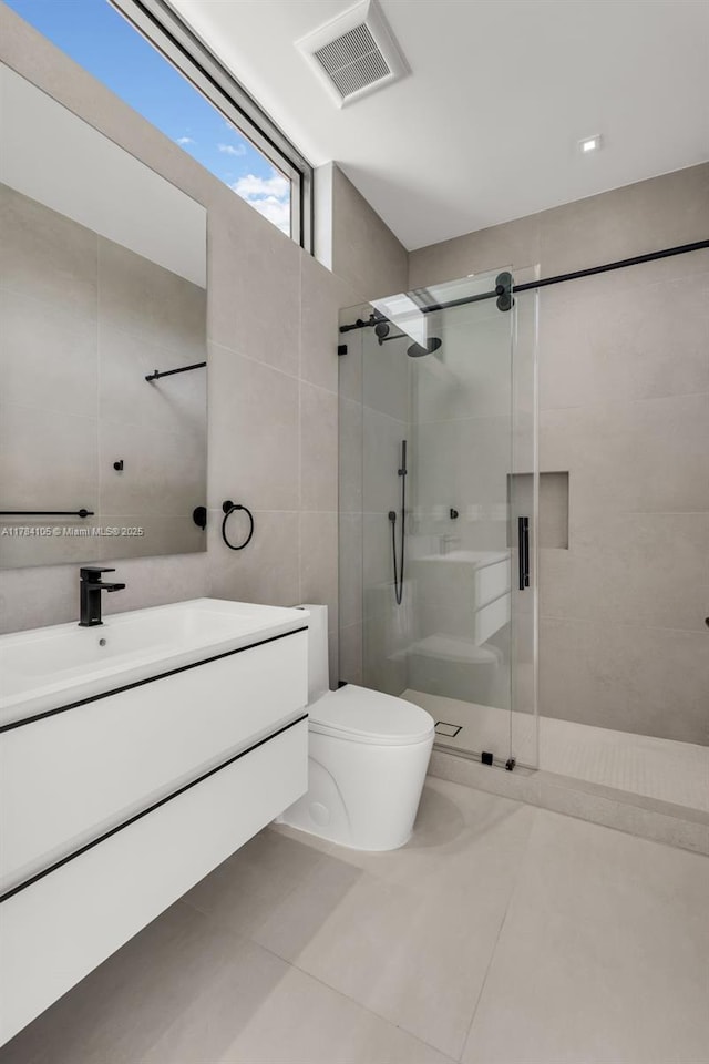bathroom featuring a shower stall, tile walls, toilet, tile patterned floors, and vanity