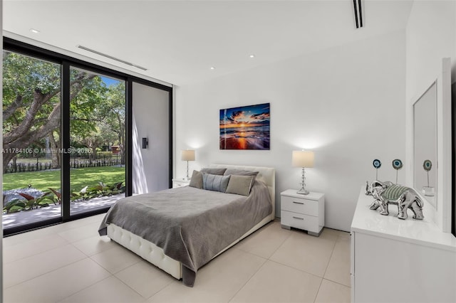 bedroom featuring light tile patterned floors, access to outside, and a wall of windows