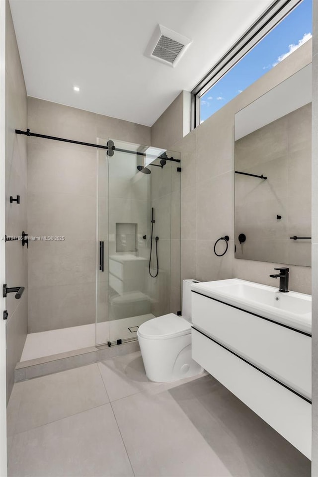 full bath featuring toilet, a stall shower, vanity, and tile patterned floors