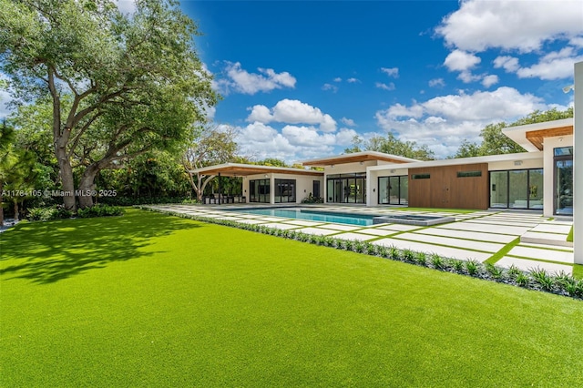 rear view of house with an outdoor pool and a patio area