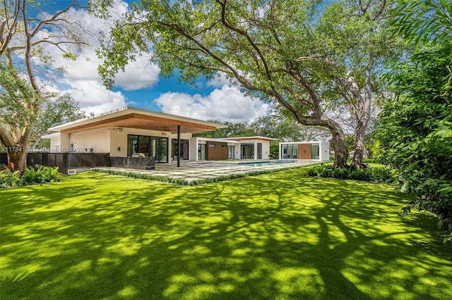 rear view of property with stucco siding, a patio area, and a ceiling fan
