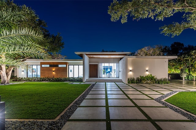 back of house at night with a lawn