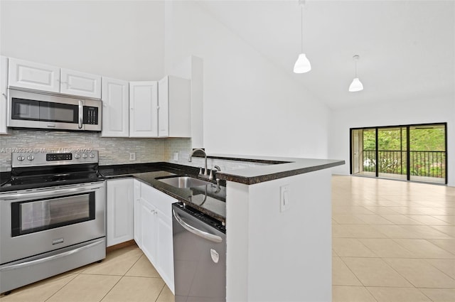 kitchen featuring high vaulted ceiling, light tile patterned floors, a sink, and appliances with stainless steel finishes