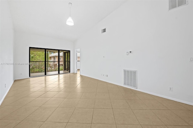 empty room featuring visible vents, baseboards, and high vaulted ceiling