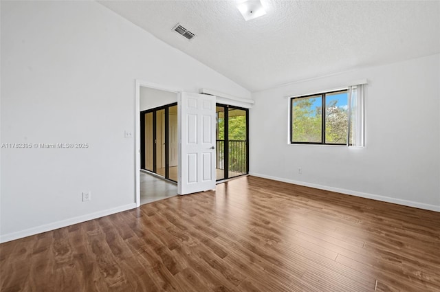 unfurnished bedroom with visible vents, a textured ceiling, wood finished floors, access to outside, and lofted ceiling