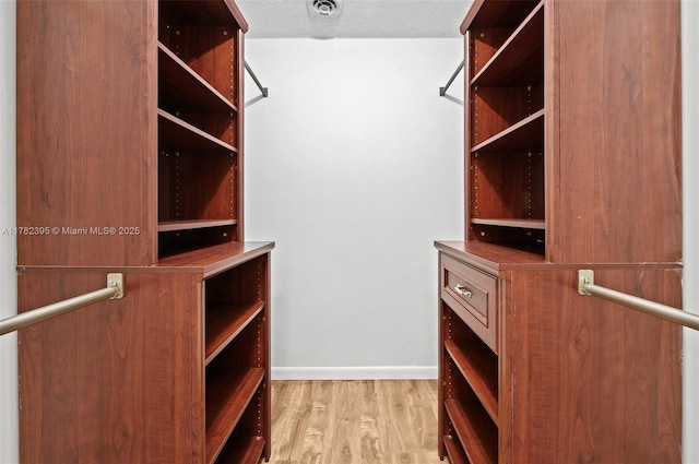 spacious closet featuring visible vents and wood finished floors