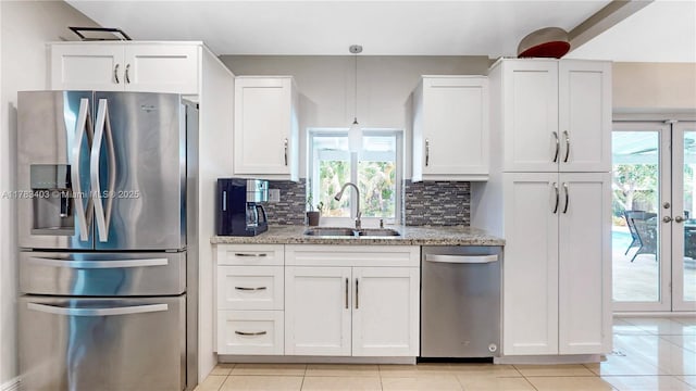 8435 SW 157th St, Palmetto Bay, FL 33157 - kitchen featuring white cabinetry, light stone countertops, decorative backsplash, stainless steel appliances, and a sink