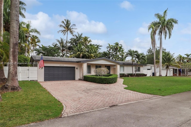 8435 SW 157th St, Palmetto Bay, FL 33157 - view of front of house featuring an attached garage, fence, stucco siding, a front lawn, and decorative driveway