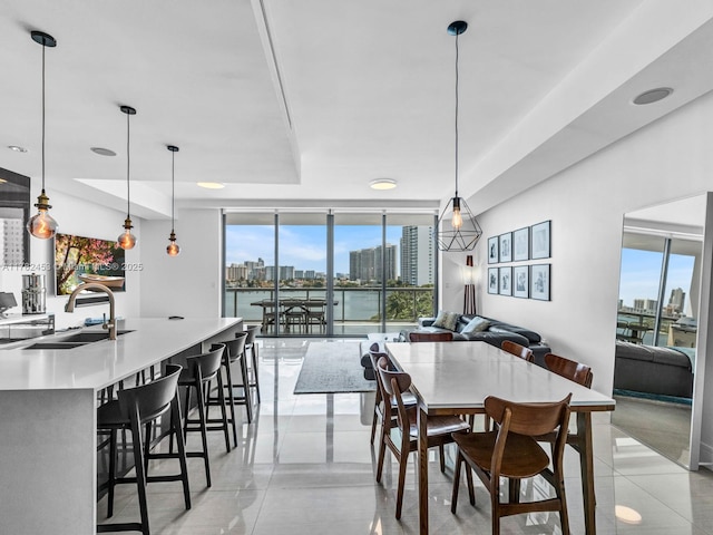 dining room featuring a view of city, floor to ceiling windows, plenty of natural light, and light tile patterned floors