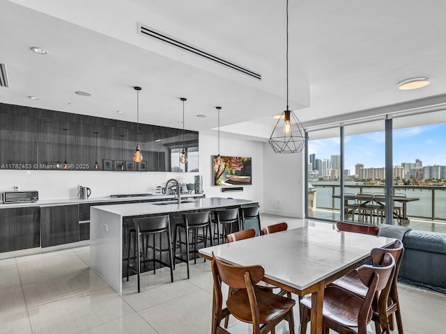 dining area featuring a city view, a toaster, light tile patterned floors, floor to ceiling windows, and visible vents