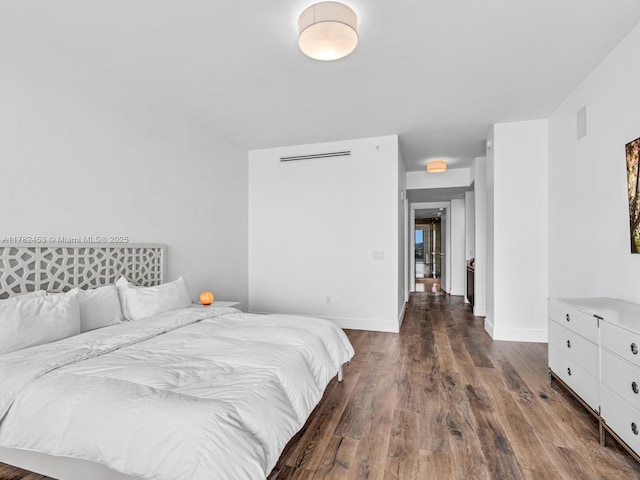 bedroom featuring wood finished floors, baseboards, and visible vents