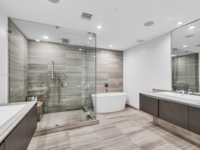 full bath with a shower stall, vanity, and visible vents