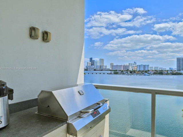 balcony featuring area for grilling, a view of city, and a water view