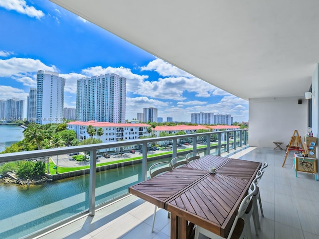 balcony featuring a water view and a city view