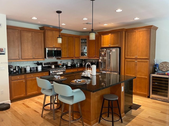 3142 NW 124th Way, Sunrise, FL 33323 - kitchen featuring stainless steel appliances, beverage cooler, brown cabinetry, light wood-style floors, and a kitchen island with sink