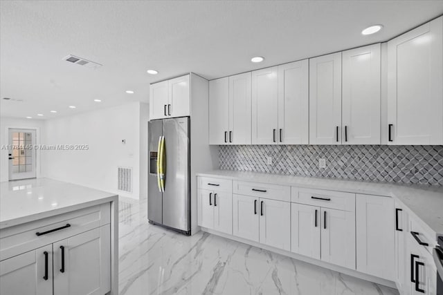 9150 Genesee St, Port Charlotte, FL 33981 - kitchen with tasteful backsplash, white cabinetry, stainless steel refrigerator with ice dispenser, and marble finish floor