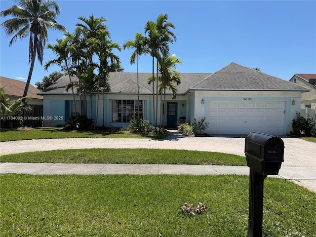 ranch-style house with a garage, stucco siding, a front lawn, driveway, and roof with shingles