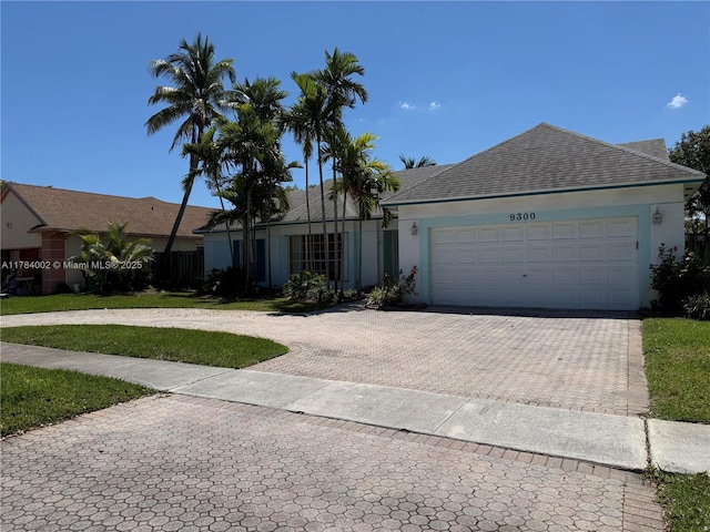 single story home featuring a garage, stucco siding, decorative driveway, and a shingled roof