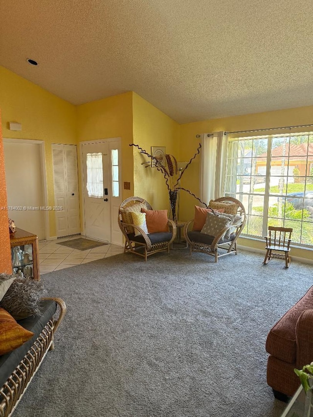 interior space with tile patterned floors, carpet flooring, a textured ceiling, and vaulted ceiling