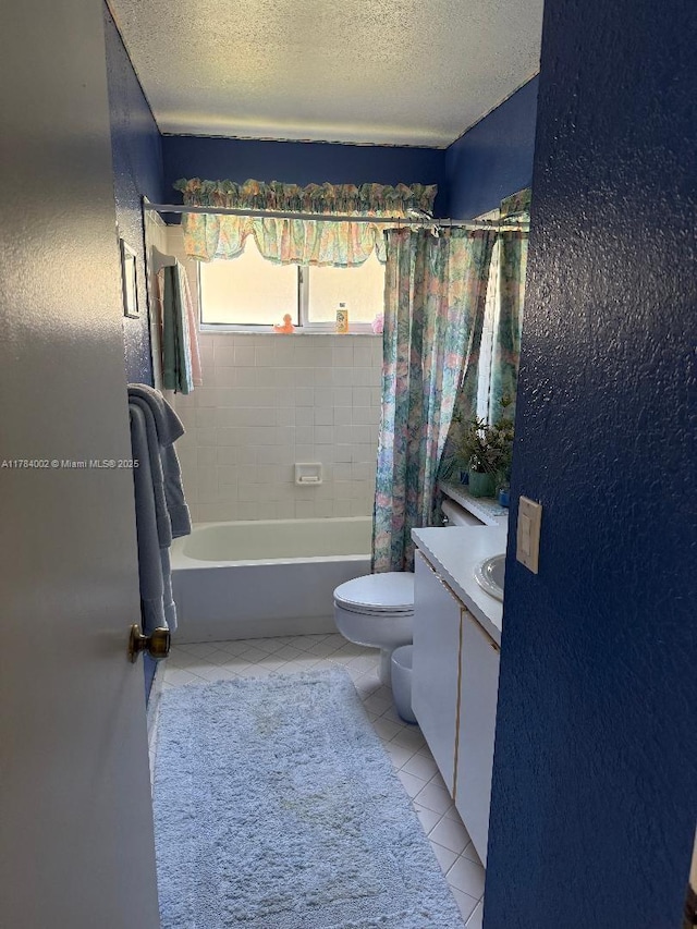 full bath featuring toilet, tile patterned floors, shower / tub combo with curtain, and a textured ceiling