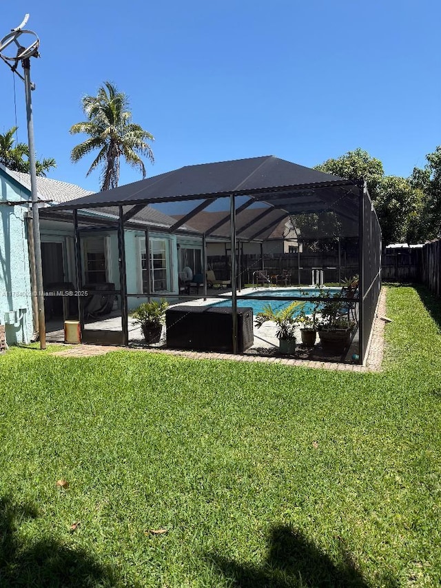 exterior space featuring a yard, an outdoor pool, a fenced backyard, and a lanai