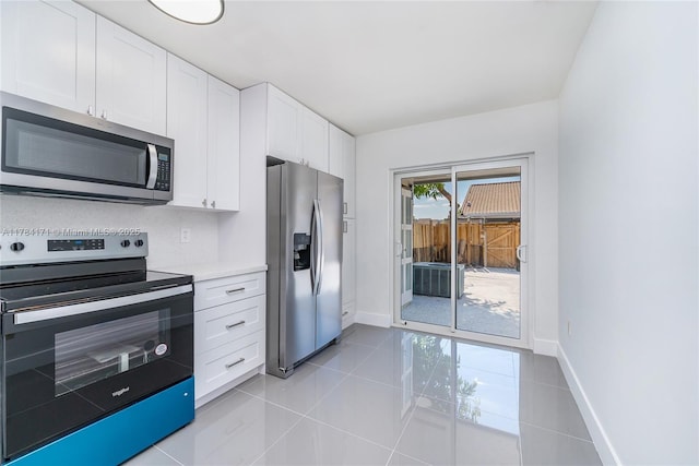 8352 SW 148th Ave, Miami, FL 33193 - kitchen featuring baseboards, light countertops, white cabinetry, light tile patterned flooring, and stainless steel appliances