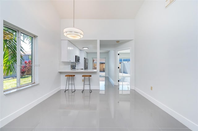 8352 SW 148th Ave, Miami, FL 33193 - kitchen featuring appliances with stainless steel finishes, light tile patterned floors, white cabinetry, and a healthy amount of sunlight