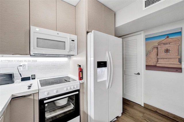 322 Taylor St Unit 1D, Hollywood, FL 33019 - kitchen featuring white appliances, light wood-style floors, light countertops, and tasteful backsplash