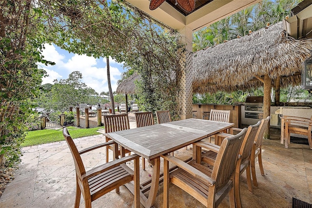 view of patio / terrace with outdoor dining space, exterior kitchen, and a grill