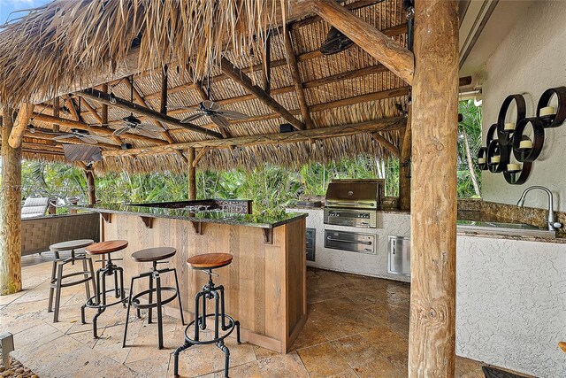 view of patio featuring a sink, a gazebo, exterior kitchen, a ceiling fan, and area for grilling