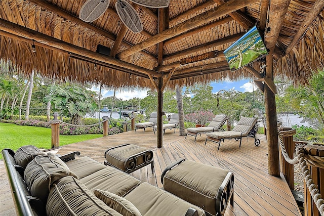 wooden deck with an outdoor living space, a gazebo, and a lawn