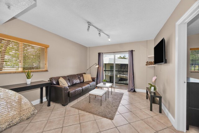 1918 Brickell Ave Unit 204, Miami, FL 33129 - living area with light tile patterned flooring, track lighting, a textured ceiling, and baseboards