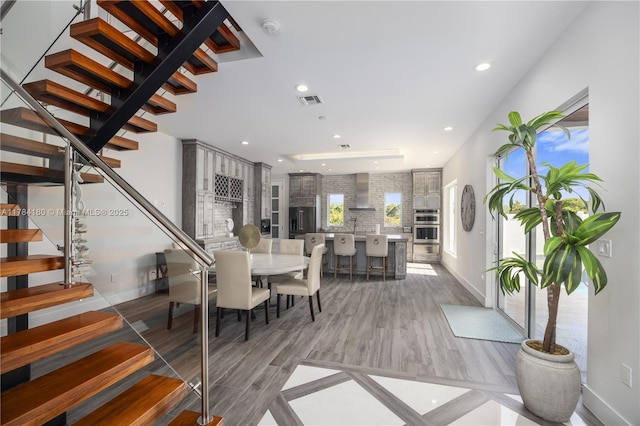 dining room with light wood-style flooring, baseboards, visible vents, recessed lighting, and stairway