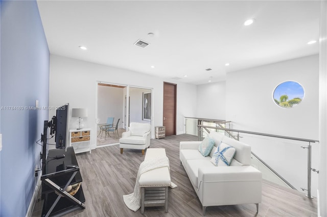 living room featuring recessed lighting, wood finished floors, visible vents, and baseboards