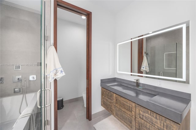 bathroom featuring vanity, a shower with door, baseboards, toilet, and tile patterned flooring