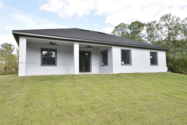 103 Scott Ave, Lehigh Acres, FL 33936 - rear view of house featuring ceiling fan, a yard, a shingled roof, and stucco siding