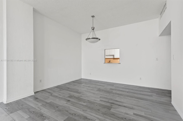 spare room featuring a textured ceiling and wood finished floors
