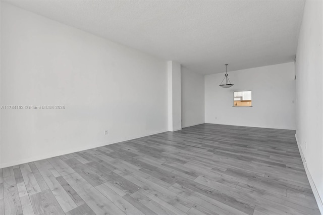 empty room featuring wood finished floors and a textured ceiling