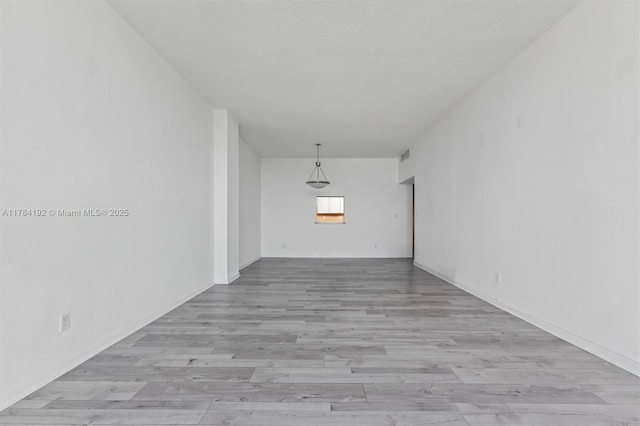spare room featuring wood finished floors and a textured ceiling