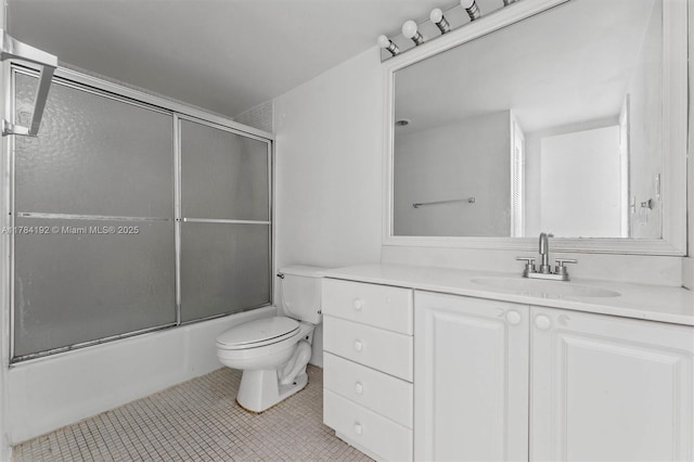 full bath with shower / bath combination with glass door, tile patterned floors, vanity, and toilet