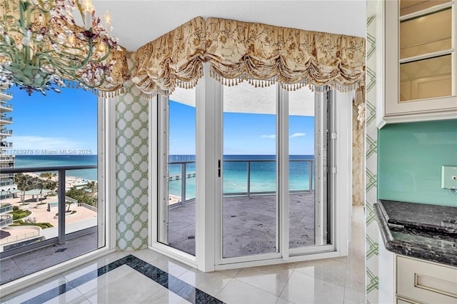 interior space with plenty of natural light, a water view, and light tile patterned floors