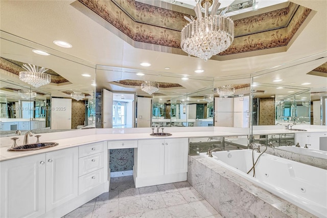 full bath featuring vanity, a whirlpool tub, recessed lighting, and a chandelier