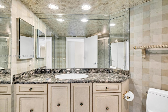 full bath with recessed lighting, tile walls, vanity, and toilet
