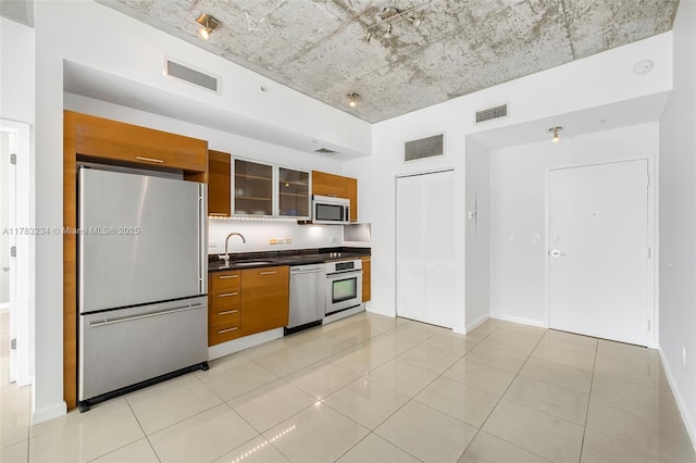 3470 E Coast Ave Unit H2706, Miami, FL 33137 - kitchen featuring appliances with stainless steel finishes, brown cabinets, dark countertops, and modern cabinets