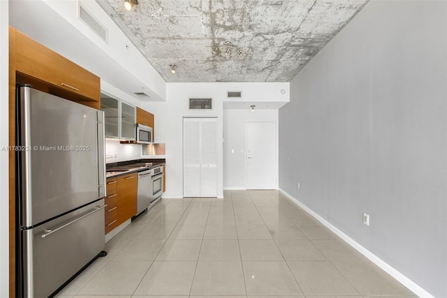 3470 E Coast Ave Unit H2706, Miami, FL 33137 - kitchen featuring appliances with stainless steel finishes, brown cabinets, glass insert cabinets, light tile patterned floors, and modern cabinets
