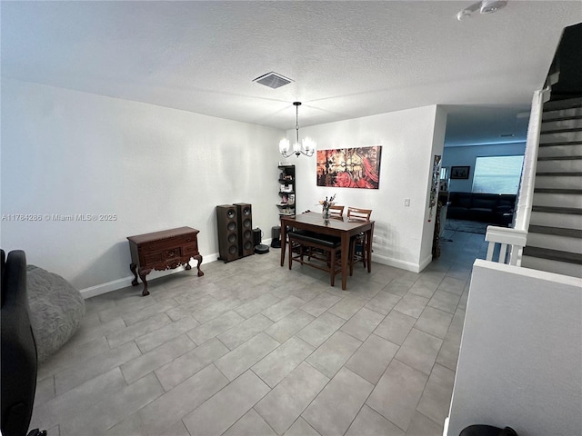 dining space featuring a textured ceiling, visible vents, a notable chandelier, and baseboards