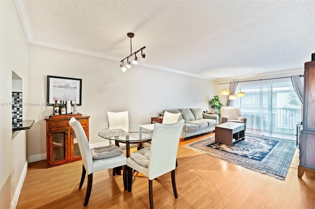 3000 Riverside Dr Unit 309-1, Coral Springs, FL 33065 - dining space featuring baseboards, rail lighting, light wood-style flooring, a textured ceiling, and crown molding