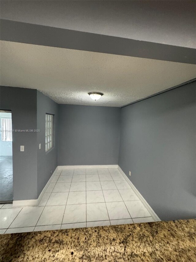 5955 NW 25th Ct Unit 208, Sunrise, FL 33313 - empty room with light tile patterned floors, light colored carpet, and a textured ceiling