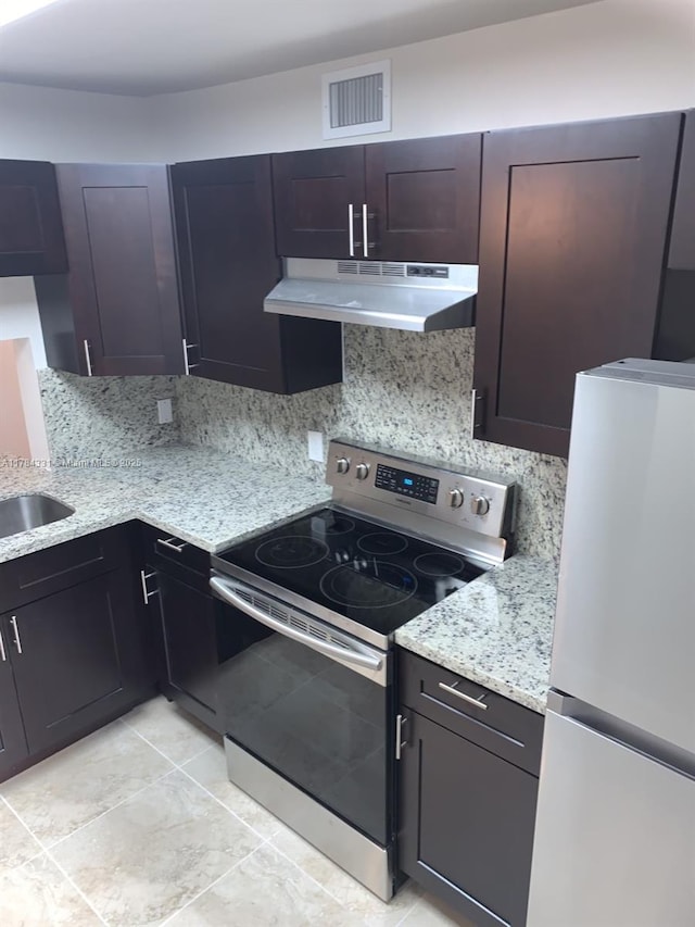 5955 NW 25th Ct Unit 208, Sunrise, FL 33313 - kitchen with stainless steel electric range oven, freestanding refrigerator, under cabinet range hood, and decorative backsplash