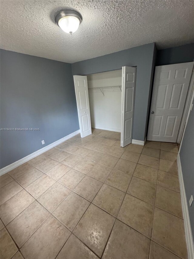 5955 NW 25th Ct Unit 208, Sunrise, FL 33313 - unfurnished bedroom featuring light tile patterned flooring, a textured ceiling, and a closet